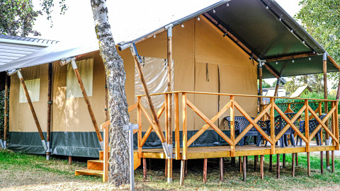 Safari-Zelt XL auf Camping Belle-Vue 2000 in Luxemburg, mit Holzveranda und Sitzmöglichkeiten draußen.