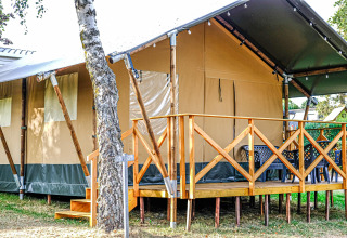 Safari-Zelt XL auf Camping Belle-Vue 2000 in Luxemburg, mit Holzveranda und Sitzmöglichkeiten draußen.