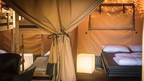 Interior de una tienda Safari XL con literas y cama doble en Camping Belle-Vue 2000 en Luxemburgo.