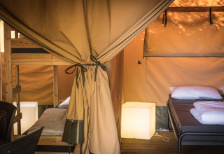 Interior de una tienda Safari XL con literas y cama doble en Camping Belle-Vue 2000 en Luxemburgo.