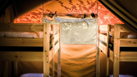 Vista interior de la Safari tent XL en Camping Belle-Vue 2000, Luxemburgo, con literas de madera.