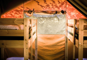 Interior view of Safari tent XL at Camping Belle-Vue 2000 in Luxembourg with wooden bunk beds.