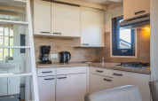 Moderna cocina pequeña en Tiny House de De Rijp, Países Bajos, con cafetera, hervidor y cocina de gas.
