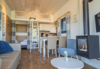 Moderne tiny house lodge ved De Rijp i Holland med hems, stue, spiseplads og brændeovn.