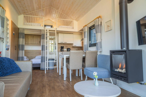Tiny House a De Rijp, Paesi Bassi, con soppalco, zona pranzo, salotto accogliente e camino moderno.