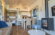 Tiny House en De Rijp, Países Bajos, con altillo, comedor, sofá acogedor y chimenea moderna.