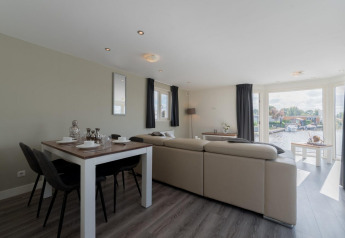 Lichte, moderne leefruimte in de Velthorst-lodge in De Rijp, Nederland, met zicht op het water.