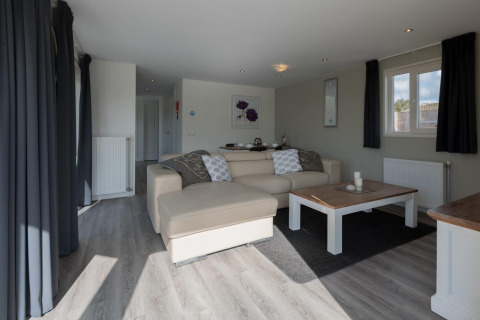 Helles und modernes Wohnzimmer in der Velthorst-Lodge in De Rijp, Niederlande, mit Sofa und Tisch.