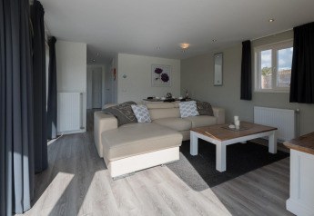 Lichte en moderne woonkamer in de Velthorst-lodge in De Rijp, Nederland, met zetel en salontafel.