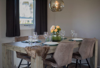 Moderne eethoek in lodge Velthorst bij De Rijp, Nederland met stijlvolle tafel en verse bloemen.