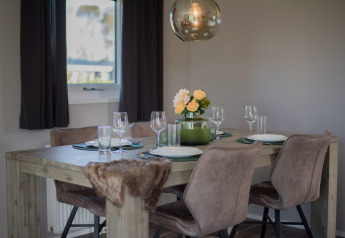 Moderne eethoek in de Velthorst-lodge te De Rijp, Nederland, met stijlvolle tafel en bloemen.