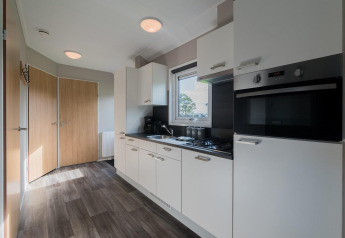 Moderne keuken in een lodge in Velthorst, De Rijp, Nederland, met witte kasten en houten deuren.