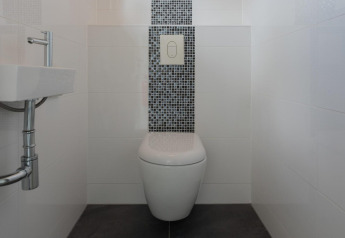 Moderne badkamer met zwevend toilet en compacte wastafel in Velthorst lodge te De Rijp, Nederland.