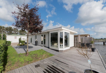 Moderne Velthorst-lodge aan het water in De Rijp, Nederland, met houten terras en grote ramen.