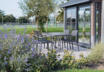 Terrasse extérieure au lodge Velthorst à De Rijp, Pays-Bas, avec table, chaises et vue sur le jardin.