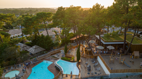 Vista aérea del parque vacacional Huttopia Arcachon en Nouvelle-Aquitaine, Francia, con piscina y área de juegos.