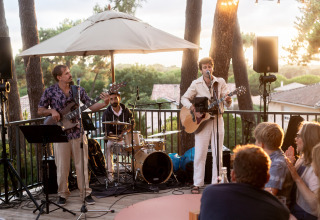 Live muziekopvoering buiten bij Huttopia Arcachon vakantiepark in Frankrijk, met muzikanten en publiek.