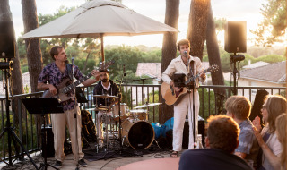 Concierto al aire libre en el parque vacacional Huttopia Arcachon en Francia, con músicos y público.
