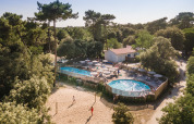 Luftfoto af ferieparken Huttopia Oléron les Pins med pool, volleyballbane og omgivet af skov i Frankrig.