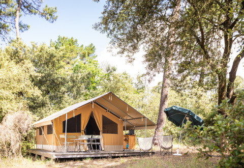 Tienda de glamping en Huttopia Oléron les Pins, rodeada de naturaleza en el parque de vacaciones, Francia.