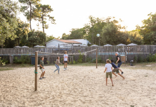 Kinderen spelen strandvolleybal bij Huttopia Oléron les Pins, een vakantiepark in Nouvelle-Aquitaine, Frankrijk.
