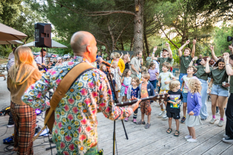 Liveband speelt voor dansende kinderen en gezinnen in het vakantiepark Huttopia Oléron les Pins, Frankrijk.