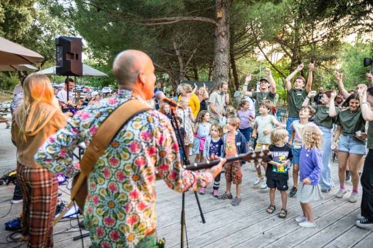 Groupe de musique jouant pour des enfants et familles dansantes à Huttopia Oléron les Pins, France.