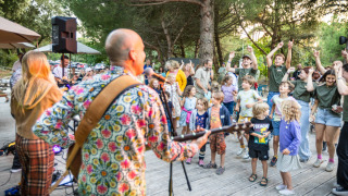 Banda en vivo tocando para niños y familias que bailan en Huttopia Oléron les Pins, parque vacacional en Francia.