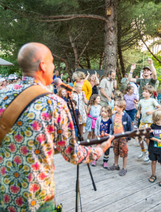 Banda en vivo tocando para niños y familias que bailan en Huttopia Oléron les Pins, parque vacacional en Francia.