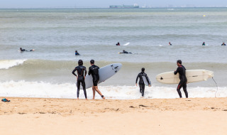 Surfistas con trajes de neopreno se preparan para entrar al mar en la playa de Saint Trojan les Bains, Nouvelle-Aquitaine.