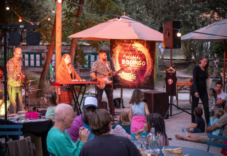 Live band performing outdoors at Huttopia Oléron les Pins holiday park, families enjoying the evening.