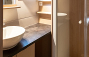 Moderne badkamer in Chalet Evasion bij Huttopia Arcachon, Frankrijk, met douche, waskom en open raam.