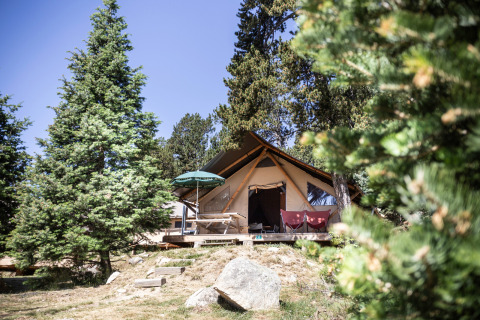 Een sfeervolle glampingtent tussen de bomen in Huttopia Font-Romeu vakantiepark, Occitanië, Frankrijk.