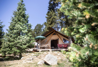 A cozy glamping tent among pine trees at Huttopia Font-Romeu holiday park in Occitanie, France.