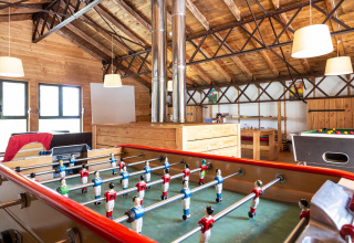 Speelruimte met tafelvoetbal en biljarttafel in Huttopia Font-Romeu vakantiepark, Occitanië, Frankrijk.