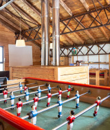 Sala de juegos con futbolín y mesa de billar en Huttopia Font-Romeu, parque vacacional en Occitania, Francia.