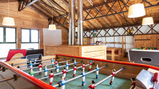 Sala de juegos con futbolín y mesa de billar en Huttopia Font-Romeu, parque vacacional en Occitania, Francia.