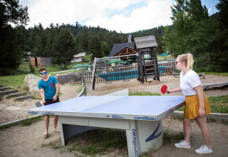 Due persone giocano a ping pong all'aperto al parco vacanze Huttopia Font-Romeu in Occitania, Francia.