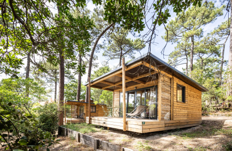 Chalet Victoria de madera en Huttopia Arcachon, Francia, rodeado de pinos y naturaleza, terraza soleada