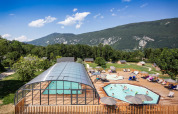 Feriepark Huttopia Lac d’Aiguebelette i Auvergne-Rhône-Alpes med swimmingpool, træterrasse og bjergudsigt.
