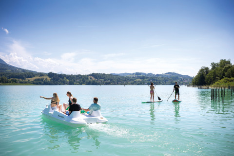 Personas disfrutan de un hidropedal y paddle surf en Huttopia Lac d’Aiguebelette, Auvergne-Rhône-Alpes.