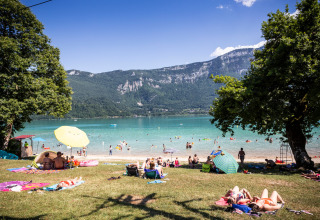Mensen genieten aan het meer bij Saint Alban de Montbel, omgeven door bergen in het Franse landschap.