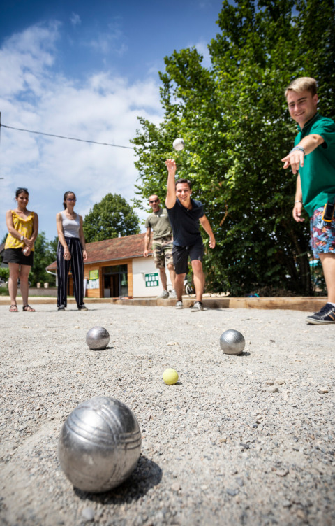 Menschen spielen Boule auf einem Kiesplatz bei Huttopia Lac d’Aiguebelette in Auvergne-Rhône-Alpes, Frankreich.