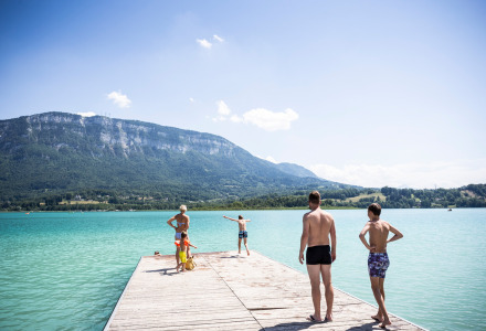 Familia disfrutando de un día soleado en un muelle junto al lago en Saint Alban de Montbel, Francia.