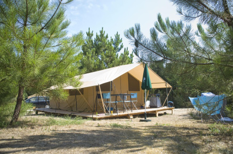 Tienda safari Toile&Bois tent Sweet en Huttopia Oléron les Pins, Francia, rodeada de pinos altos.