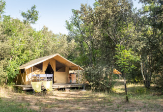 Tienda tipo safari Bungalow Classic entre árboles en Huttopia Oléron les Pins, Francia, ambiente veraniego.
