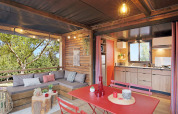 Interior de la tienda safari Arizona en Huttopia Oléron les Pins, Francia, con cocina y terraza acogedora.