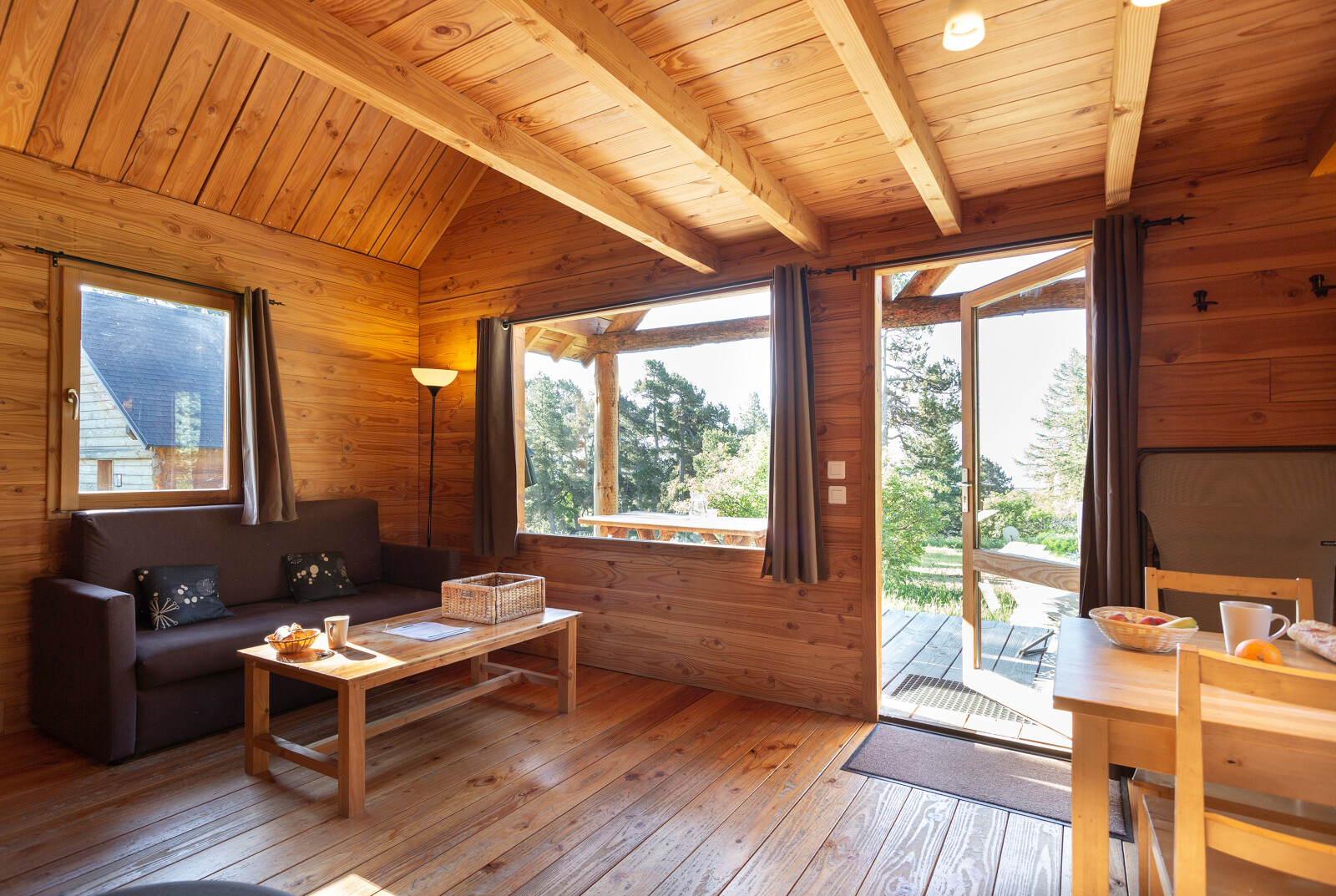 Houten interieur van Chalet 'The Cabin' bij Huttopia Font-Romeu in Frankrijk met uitzicht op het groen.