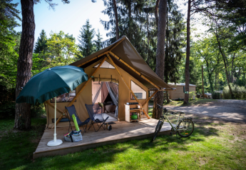 Safari telt Trappeur ved Huttopia Font-Romeu i Frankrig, med terrasse, cykel og parasol i skoven.