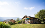 Chalet Montana, en træhytte med veranda og cykler, omgivet af natur ved Huttopia Lac d’Aiguebelette, Frankrig.